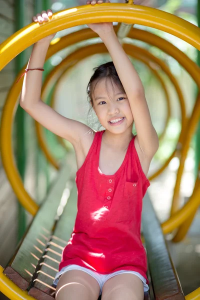 Söt vacker leende liten flicka på en lekplatsutrustning — Stockfoto