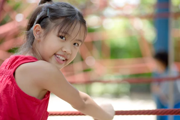 Lindos niños. Chica asiática escalando en una estructura de patio de cuerda en el parque de aventuras —  Fotos de Stock