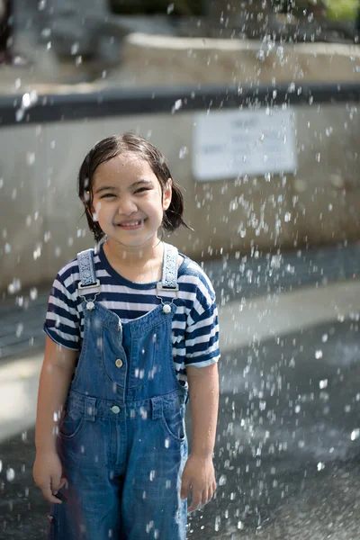 アジアの女の子は水の公園の噴水で遊んで — ストック写真