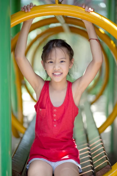 Söt vacker leende liten flicka på en lekplatsutrustning — Stockfoto