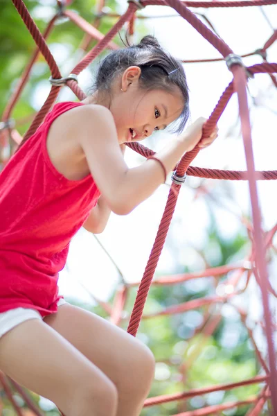 Niedliche Kinder. Asiatin klettert in Seilspielanlage im Abenteuerpark — Stockfoto
