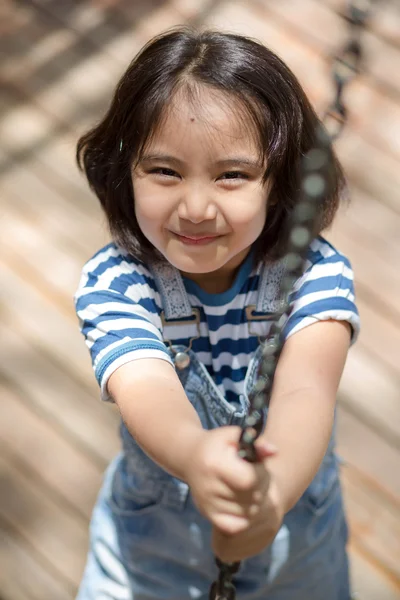 Lindos niños. Chica asiática escalando en una estructura de parque infantil de cadena en el parque de aventuras — Foto de Stock