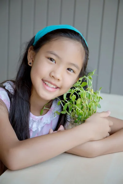 快乐的亚洲女孩拥抱树盆栽 — 图库照片