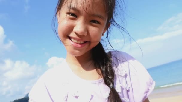 Медленное движение азиатской девушки, играющей с маленьким крабом на песчаном пляже — стоковое видео