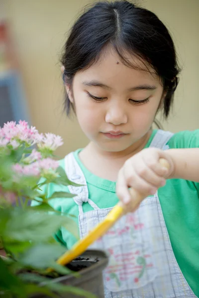 Pequena criança asiática plantando flor — Fotografia de Stock
