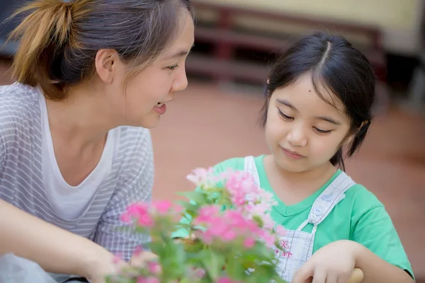 Kleines asiatisches Kind pflanzt Blume mit ihrer Mutter — Stockfoto