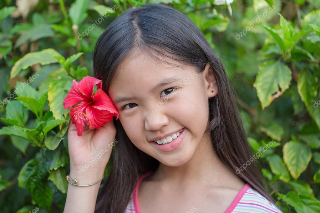 Little Asian Girl Smiling With Chinese Rose In The Garden Stock Photo Little Asian Girl Smiling With Chinese Rose In The Garden Stock Photo