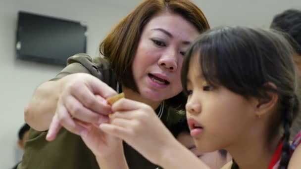 4K: Niño asiático aprendiendo a doblar origami de papel japonés con maestro, arte de doblar papel . — Vídeos de Stock