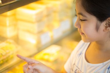 Seyir ve vitrin farklı kek ile gösteren Asyalı kız