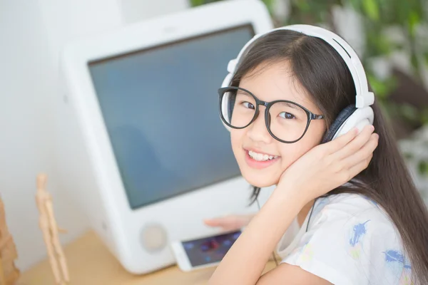 Attraente ragazza asiatica ascoltare musica su smartphone con cuffie nella stanza — Foto Stock