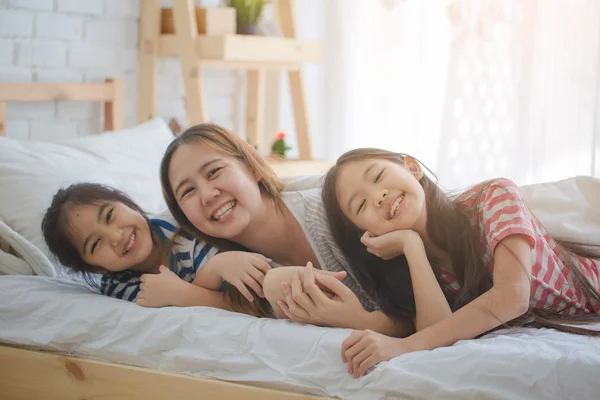 Friska asiatisk familj leende och ligger på sängen, lycklig familj — Stockfoto