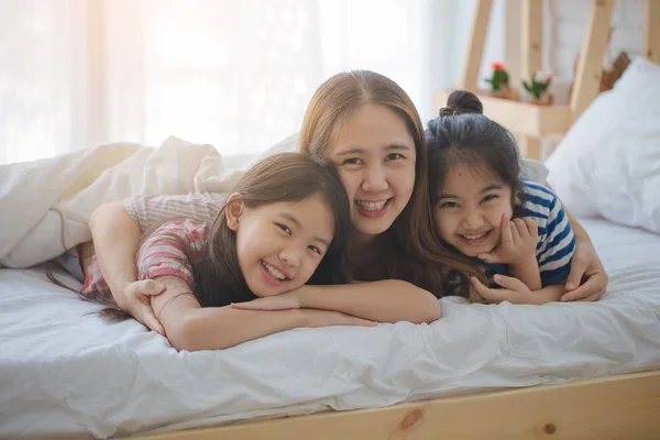 Friska asiatisk familj leende och ligger på sängen, lycklig familj — Stockfoto
