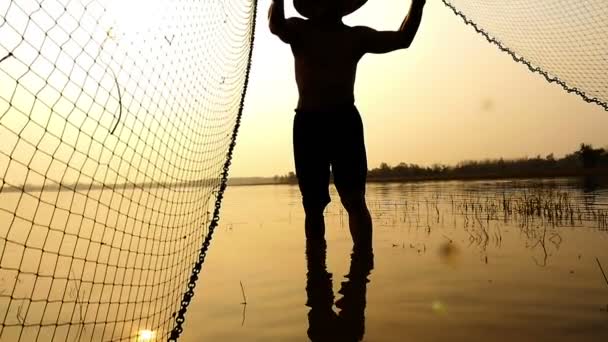 Silhouette de pêcheurs traditionnels jetant la pêche au filet dans le lac à l'heure du lever du soleil — Video