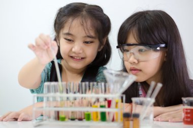 Little Asian student girl making science experiment in the laboratory class clipart