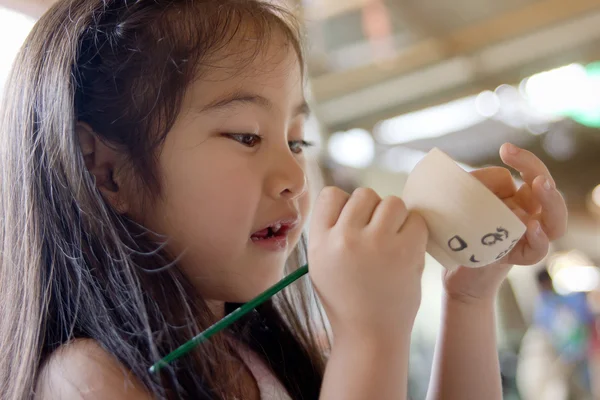Kleine asiatische Mädchen malen handgefertigte Schale aus Ton — Stockfoto
