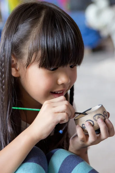 Liten asiatisk tjej målning hand hantverk skål gjord av lera — Stockfoto