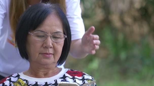 Azjatyckie kobiety zamyka oczy seniora z rąk na niespodziankę, Slow motion shot — Wideo stockowe