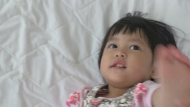 4K : Little Asian child laying and playing on the bed — Αρχείο Βίντεο