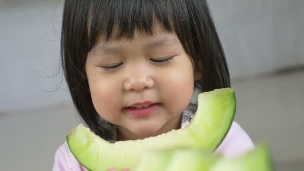 4K: Adorável menina asiática comendo delicioso melão verde — Vídeo de Stock