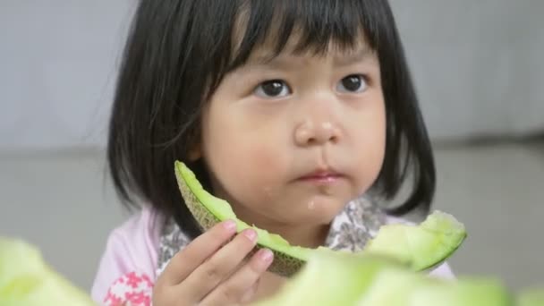 4k: mooie Aziatische kind meisje eten heerlijke groene meloen — Stockvideo