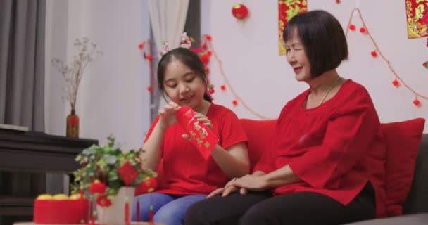 Heureuse Femme Asiatique Senior Donnant Petite Fille Une Enveloppe Rouge — Video