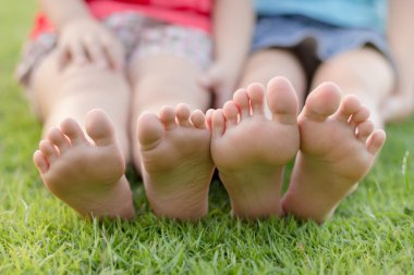 Çimenlerin üzerinde oturan çocuk