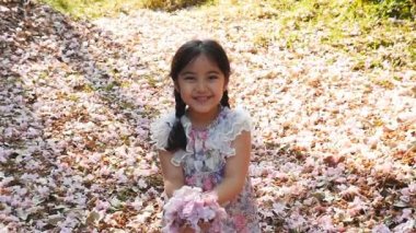 Küçük Asyalı kız çiçek atar
