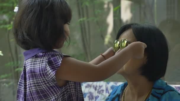 Heureuse petite-fille asiatique portant des lunettes de soleil à sa grand-mère, au ralenti — Video