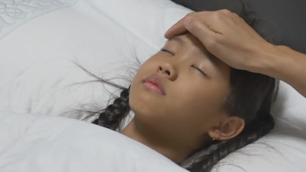 Азиатский ребенок болен и спит на кровати с матерью рядом с ней . — стоковое видео