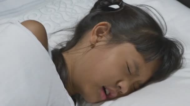 アジアの子病気と彼女の側に彼女の母親と一緒にベッドで寝ています。. — ストック動画