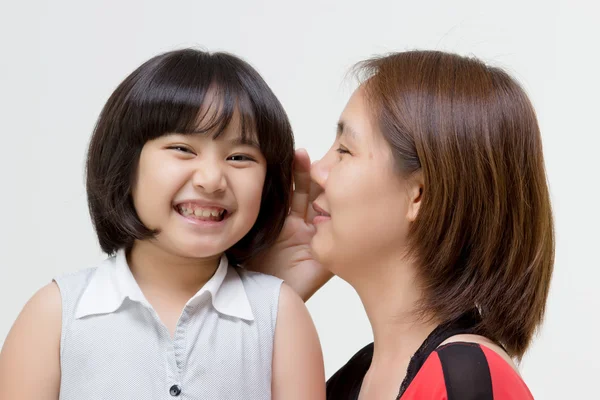 Porträt einer asiatischen Mutter flüstert ihrer Tochter auf isolierte Weise zu — Stockfoto