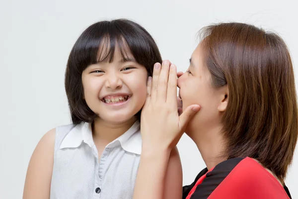 Asian mother whispering to daughter — Stock Photo, Image