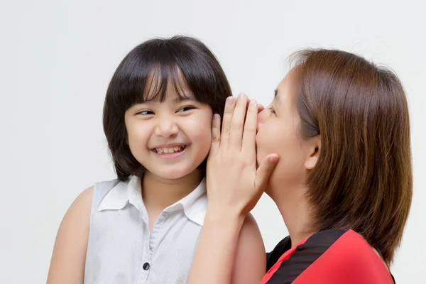 Porträt einer asiatischen Mutter flüstert ihrer Tochter auf isolierte Weise zu — Stockfoto