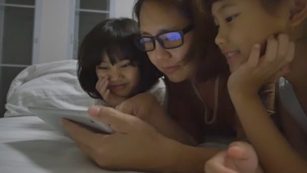 Asiática mamá se encuentra con sus hijas y juega con la tableta digital juntos — Vídeo de stock