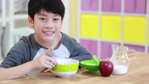 Pouco ásia menino comer cereal com leite com sorriso rosto — Vídeo de Stock