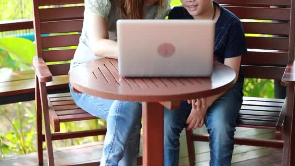Μικρά, ευτυχισμένη μητέρα με παιδί χρησιμοποιώντας φορητό υπολογιστή στη βεράντα — Αρχείο Βίντεο