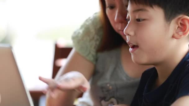 Giovane, madre felice con bambino utilizzando il computer portatile sulla terrazza — Video Stock