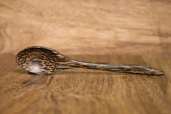 Cucchiaio di legno su fondo legno marrone scuro. — Foto Stock