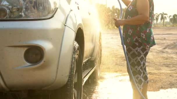 Asiática mayor mujer lavado coche familiar con tubo de agua, cámara lenta disparar con, 120 Fps por Sony A6300  . — Vídeos de Stock