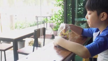 Küçük Asyalı çocuk atıştırmalık yemekten hoşlanıyor .