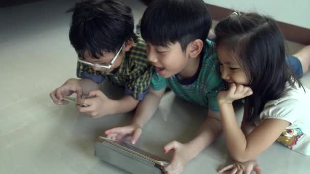 4K, Jeune asiatique enfant jouer à des jeux en ligne sur tablette et téléphone intelligent  . — Video