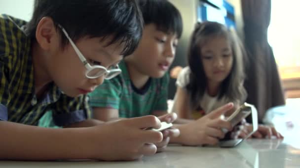 4K, Joven niño asiático jugando juegos en línea en la computadora tableta y el teléfono inteligente  . — Vídeos de Stock