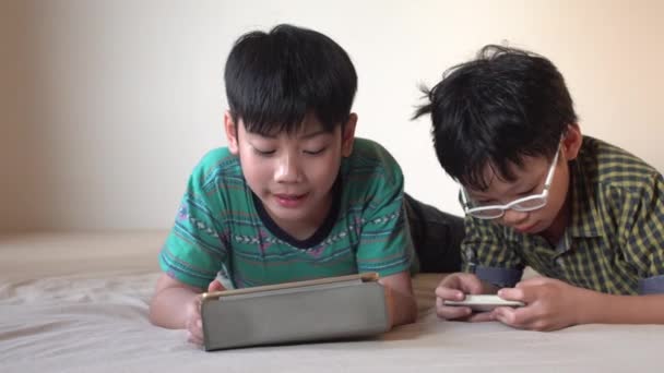 4K, Happy asian boy playing online games on tablet computer and smart phone . — Stock Video