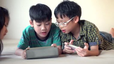 4k, tablet bilgisayar ve akıllı telefon yatak odasında oyun oynamayı mutlu Asyalı çocuk