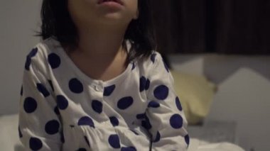 Küçük Asyalı kız yatakta televizyon izlerken