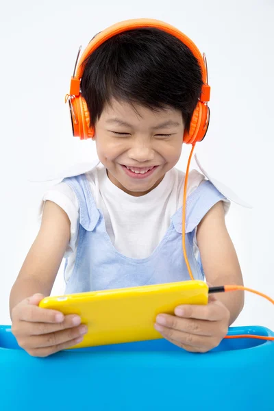 Chino feliz muchacho utilizar Tablet PC con auriculares — Foto de Stock