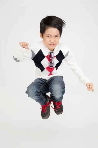 Azjatycka cute chłopiec skacze z twarzy uśmiech — Zdjęcie stockowe