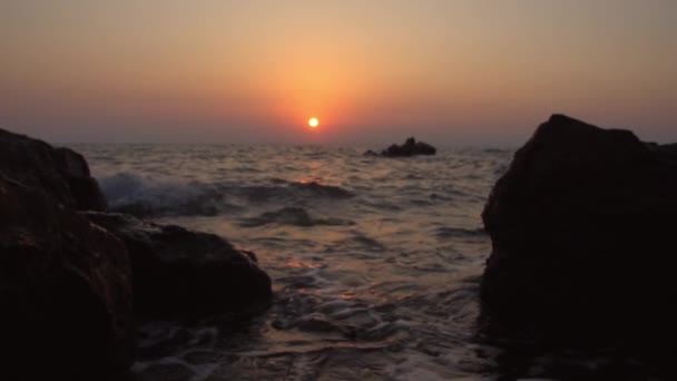 Waterspatten tegen rotsen met zonsondergang (super slow motion) — Stockvideo