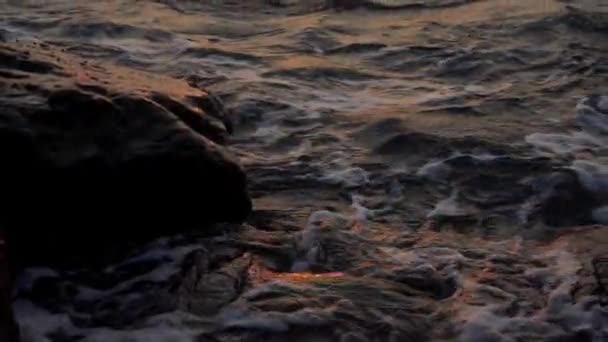Waterspatten tegen rotsen met zonsondergang (super slow motion) — Stockvideo