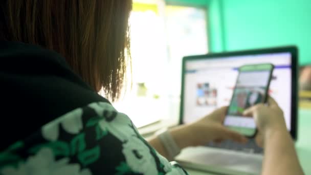 4k, mulher asiática trabalhando no laptop e uso no telefone — Vídeo de Stock